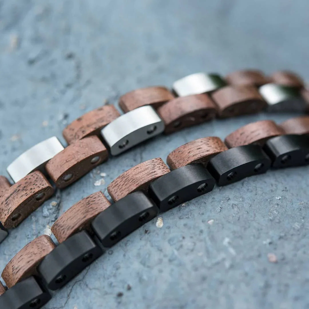 Wood and metal link bracelets on textured gray stone surface