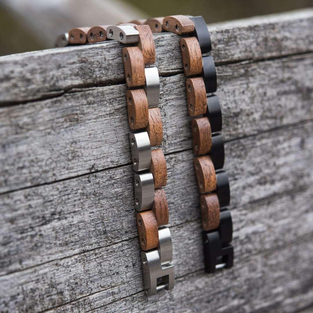 Wood and metal link bracelets resting on weathered wooden surface outdoors