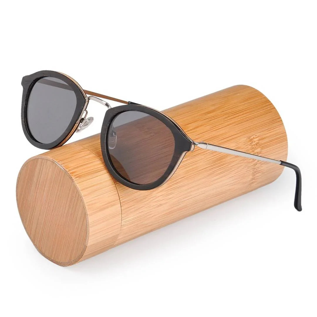 Black round sunglasses with metal temples on a cylindrical bamboo case