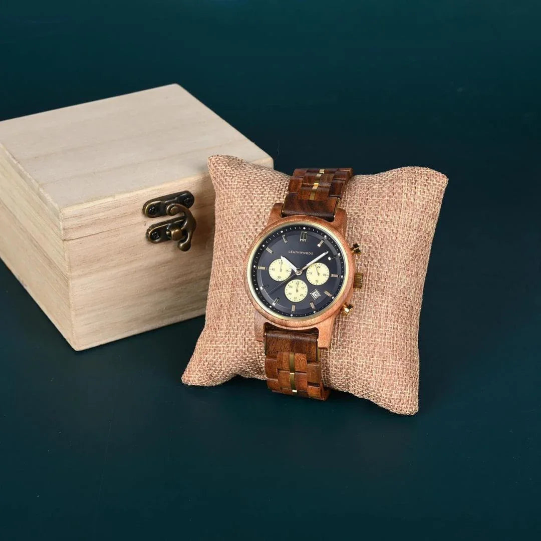 Men's wooden wristwatch with black dial on cushion, beside wooden gift box