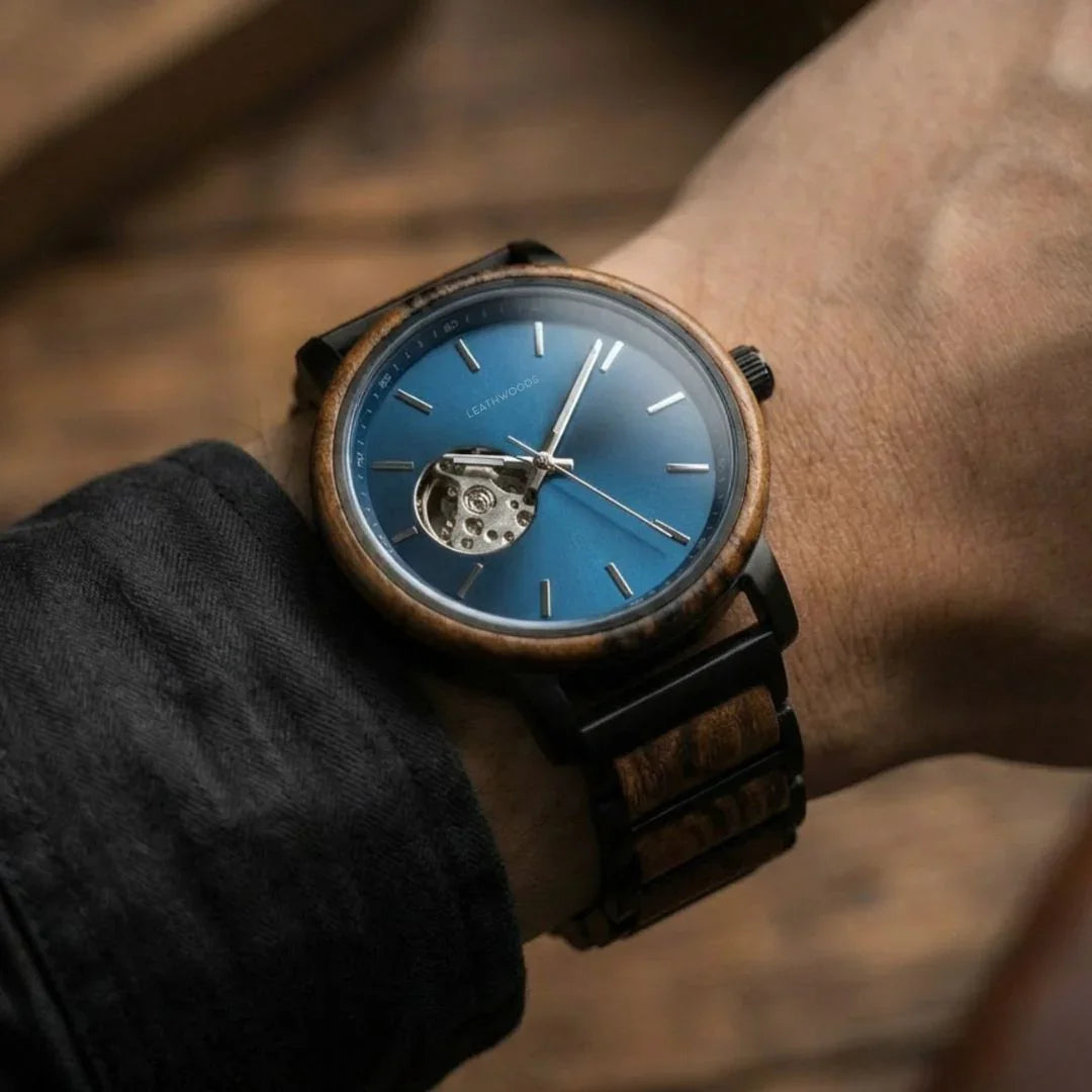 Close-up of wristwatch with wooden bezel and blue dial showing mechanical movement on wrist