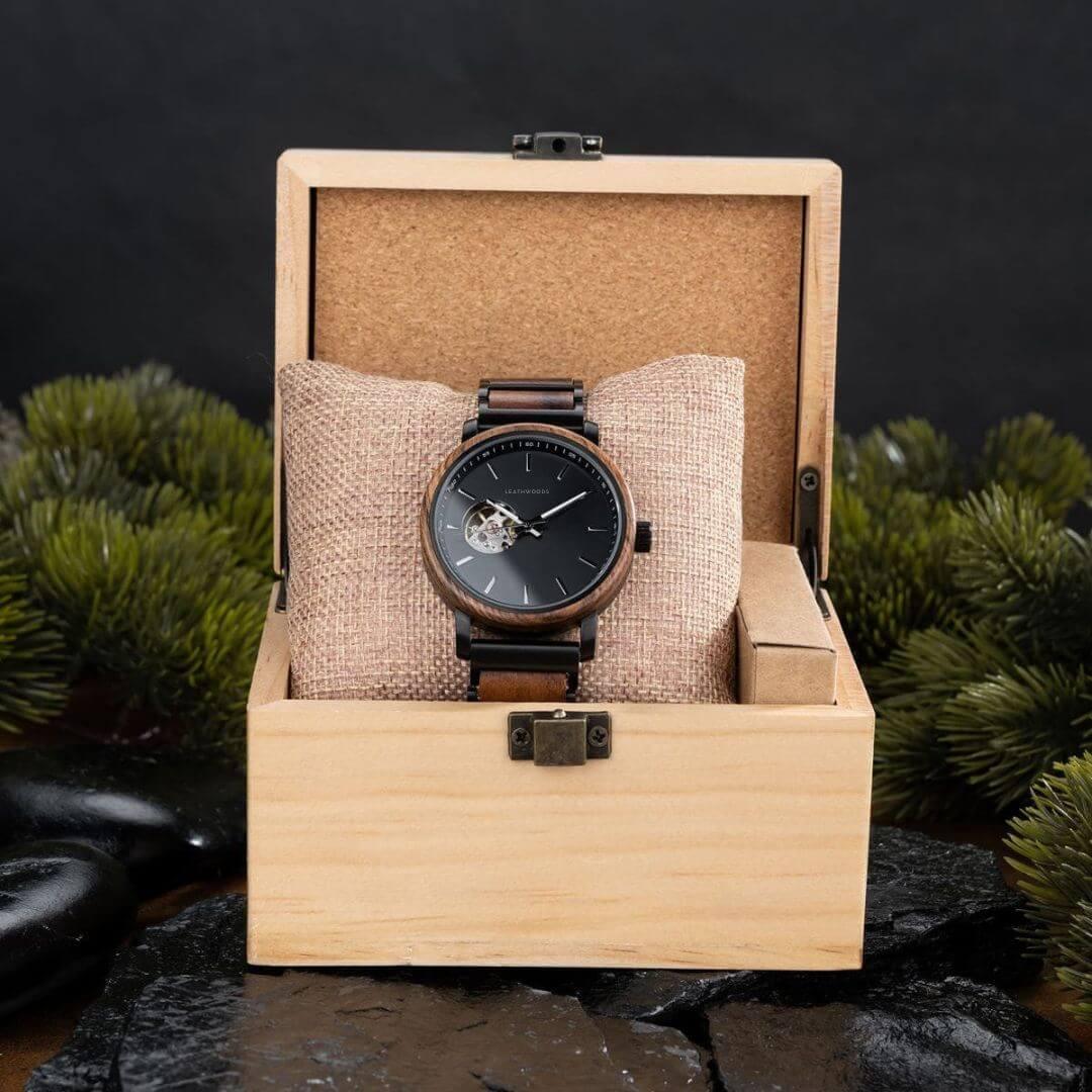 wooden wristwatch with black dial in open wooden box on textured cushion with natural decor