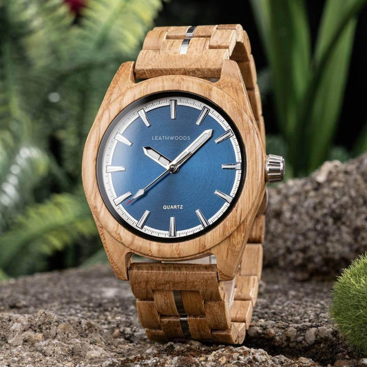 Leathwoods wooden wristwatch with blue dial and silver hands on natural stone and green foliage background