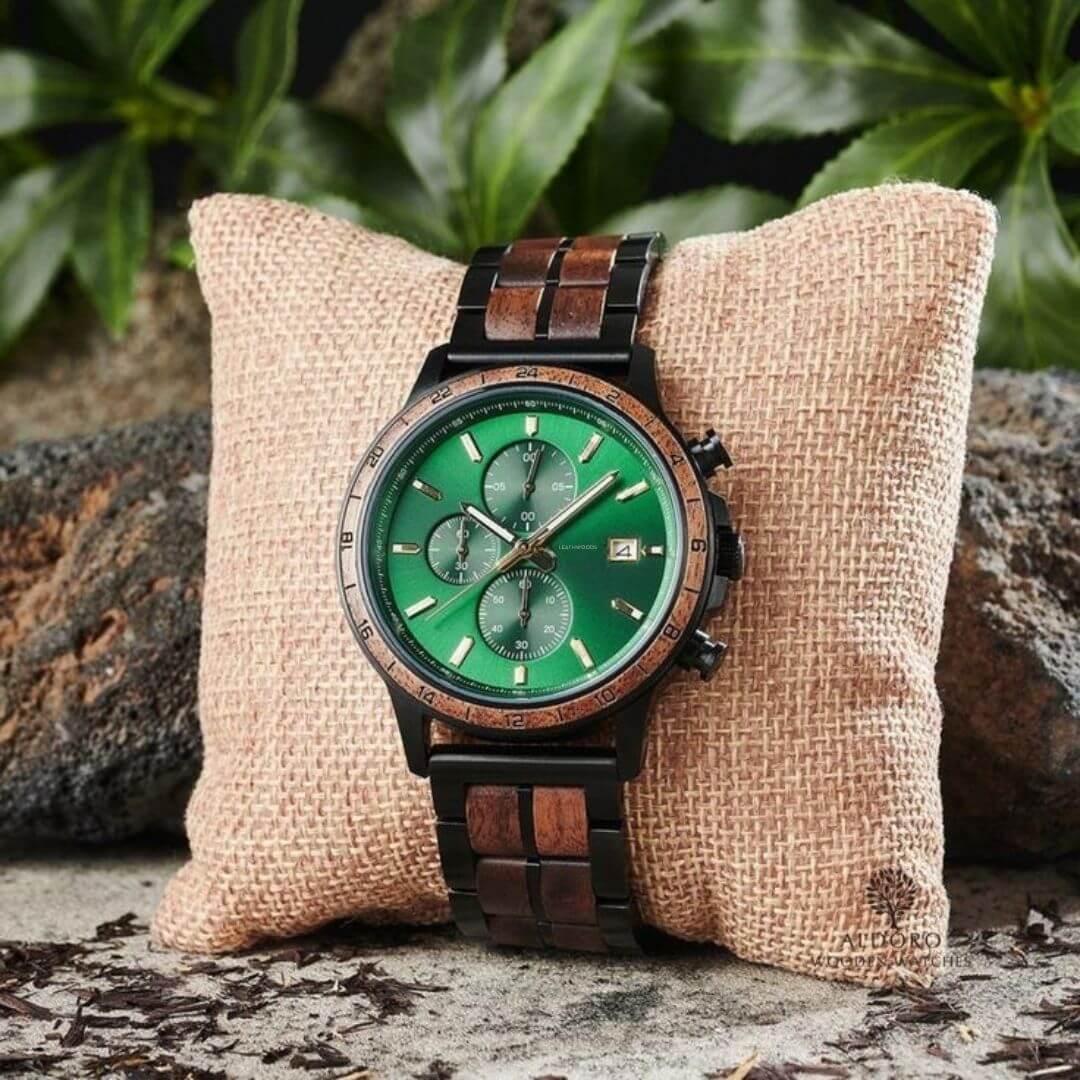 Wood and black metal wristwatch with green dial on beige pillow, natural outdoor setting