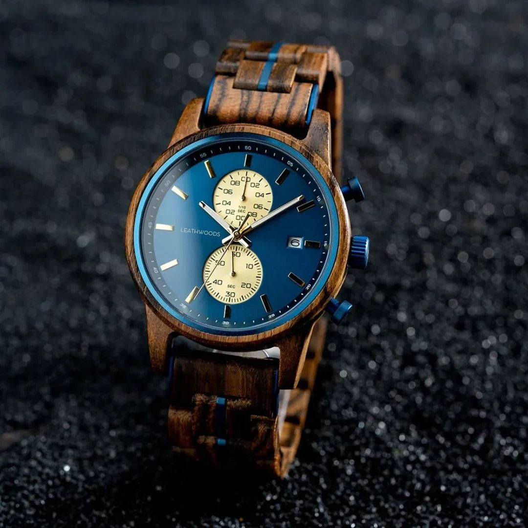 Wooden wristwatch with blue dial, gold subdials, and date display on black textured background