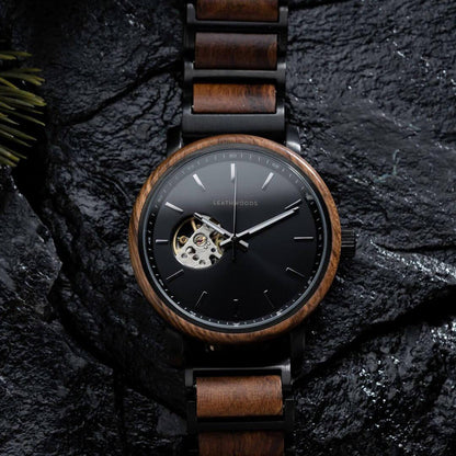 Leathwoods wristwatch with wooden bezel and band, black dial, and exposed gear detail on dark textured background