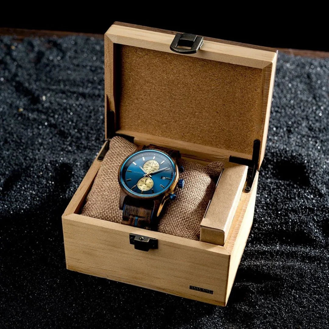 Elegant wooden wristwatch with blue dial and chronograph in open wooden gift box on black textured background