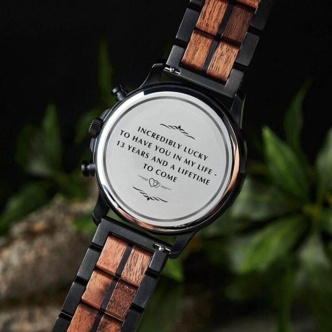 Back of wristwatch with black and wooden links featuring engraved sentimental message