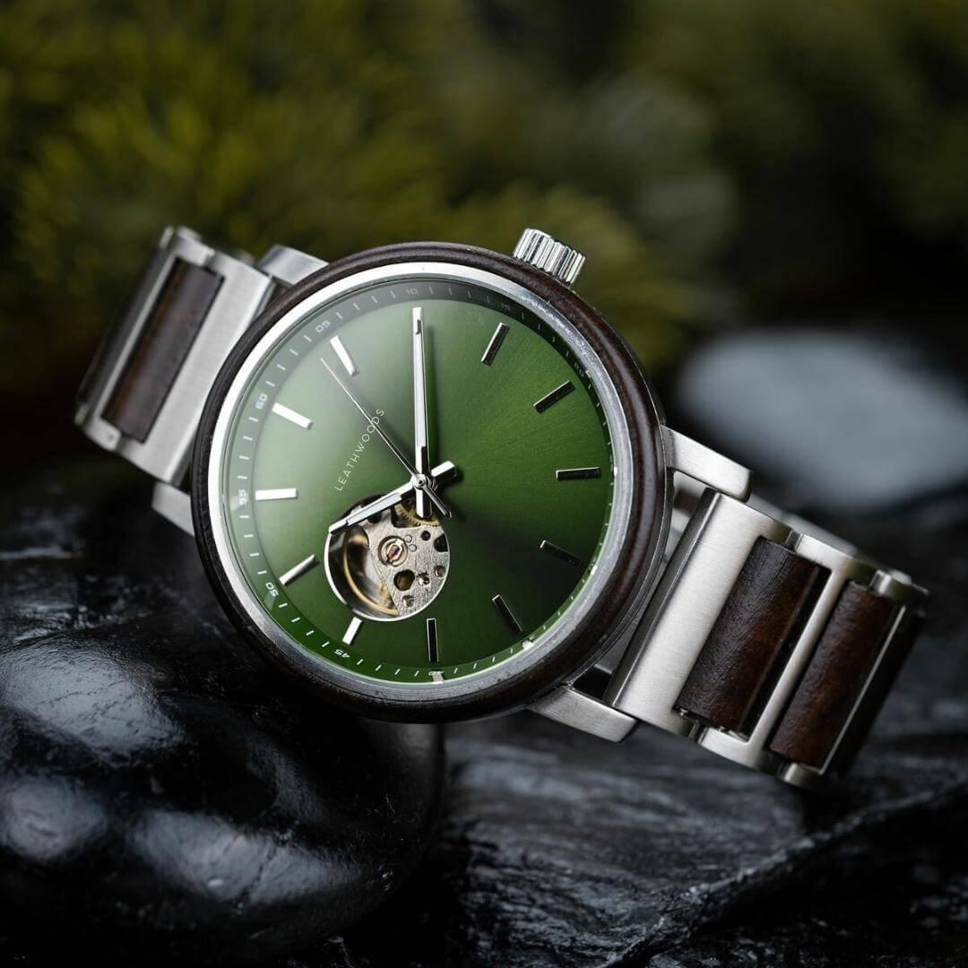 Luxury Leathwoods wristwatch with green dial, stainless steel and wood band, shown on black stones