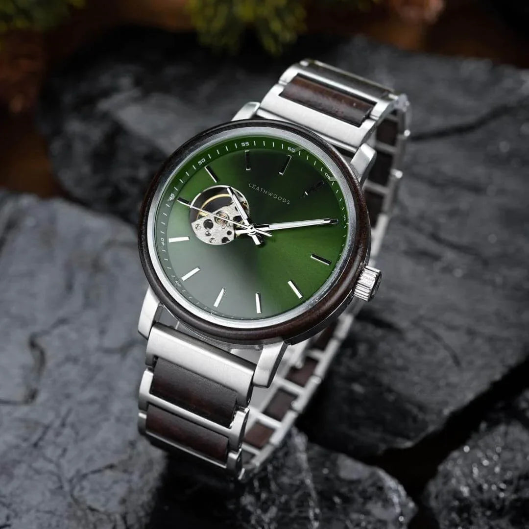 Leathwoods wristwatch with green dial, silver and wooden strap, open heart on dark stone background