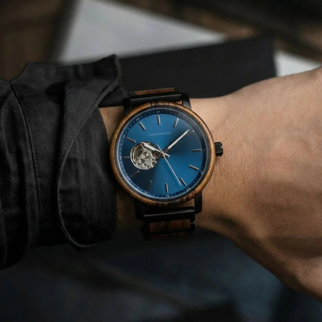 Close-up of a wrist wearing a Leathwoods wooden watch with a blue dial and visible mechanical movement