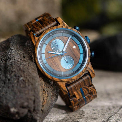 Leathwoods Morpho wooden watch with blue dials and wood grain strap on a rock