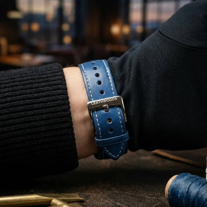 Person wearing a blue leather watch strap with 'Leathwoods' branding on a dark background.