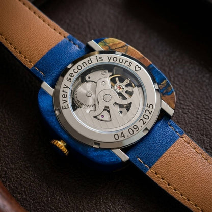 Watch with blue strap and visible mechanical components on a dark background